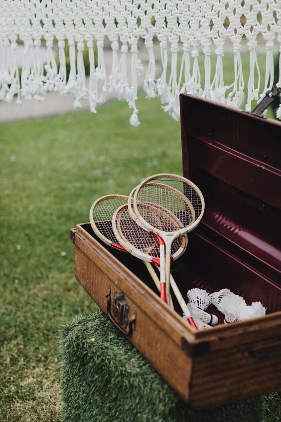 two tennis racquets are in an open suitcase on the grass near some string