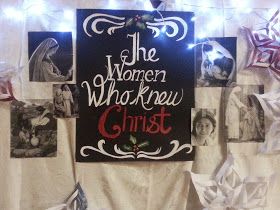 a sign that says the women who knew christ hanging on a wall with ribbons and lights