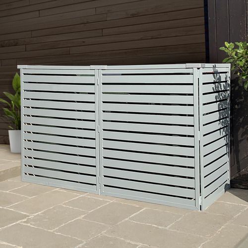 a white fence sitting on top of a sidewalk next to a planter filled with potted plants