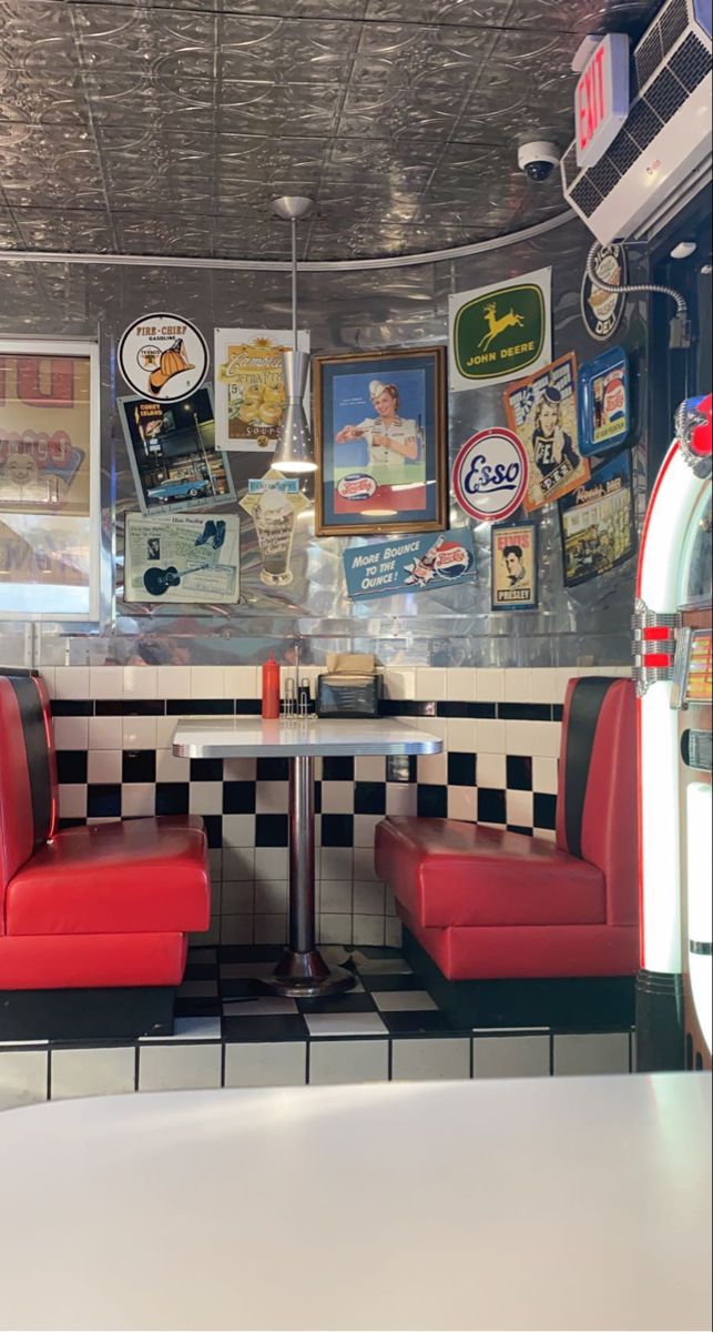 two red chairs sitting next to each other at a table in front of a checkered wall