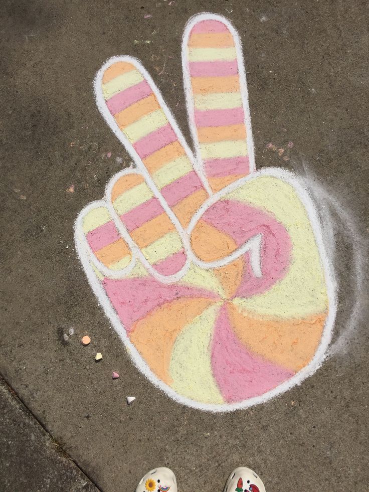 someone's feet standing in front of a hand drawn on the sidewalk with colored chalk