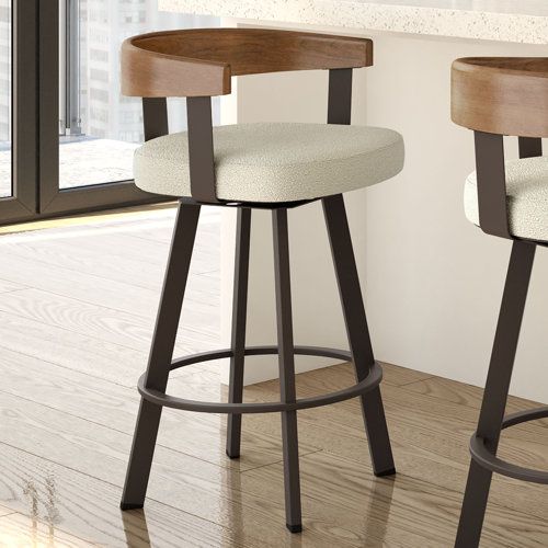 two wooden stools with white upholstered seats in front of a large window