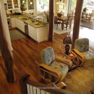 a living room and kitchen area with wood flooring in an open concept house plan