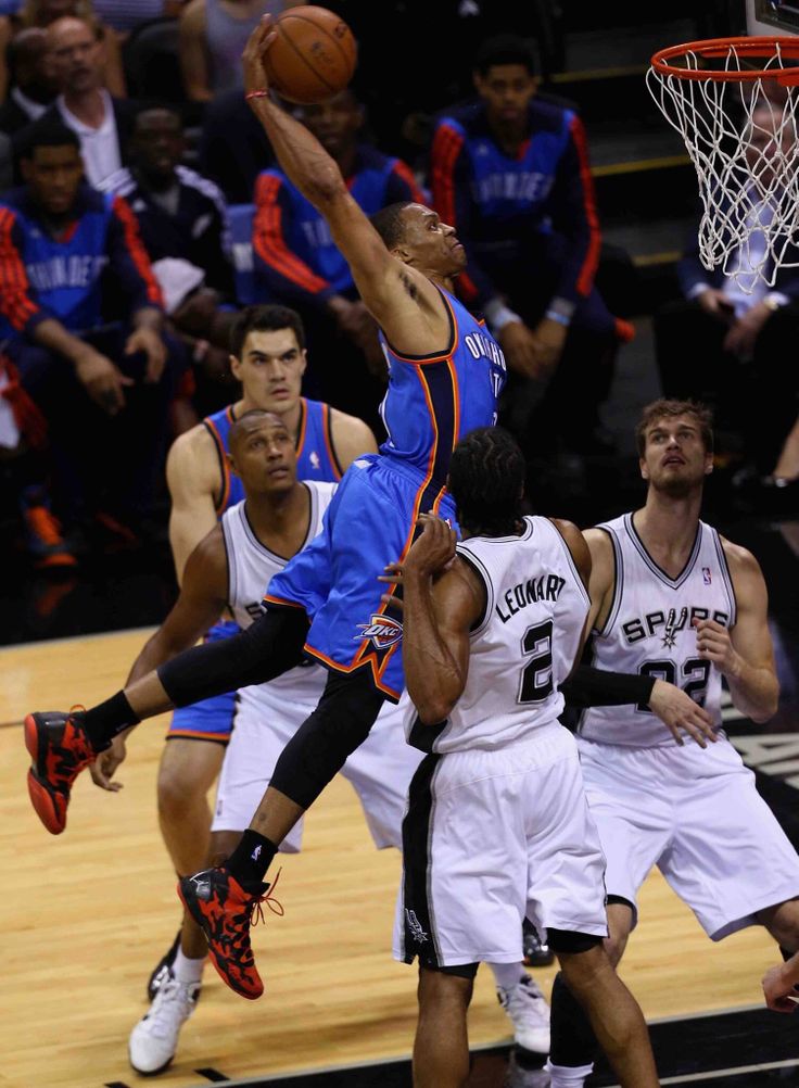 a group of men playing basketball against each other