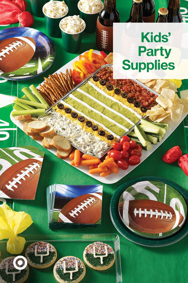 a football themed party spread with snacks and drinks on the table for kids to eat