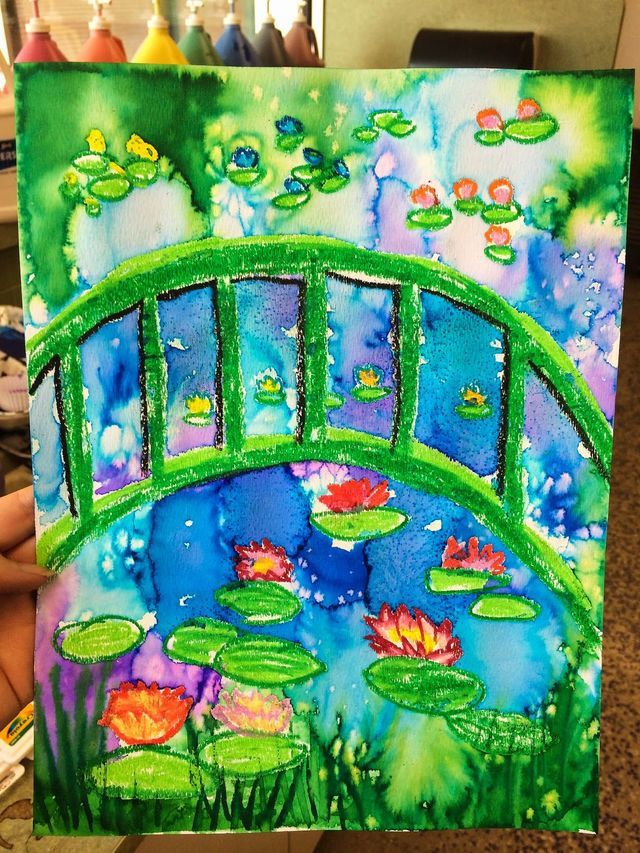 a painting with water lilies and a bridge in the background