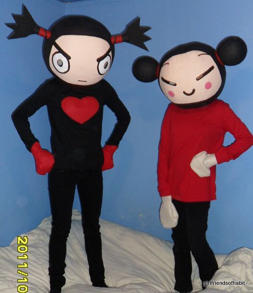 two people in mickey and minnie mouse costumes standing next to each other on a bed