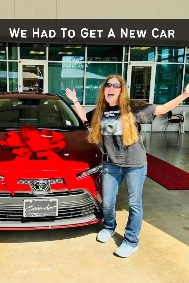 a woman standing in front of a red car with her arms out and the words, we had to get a new car