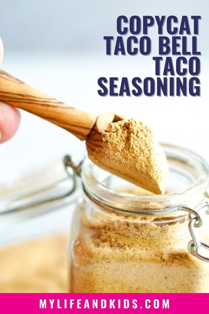 a hand holding a wooden spoon over a jar filled with taco seasoning and text that reads copycat taco bello seasoning