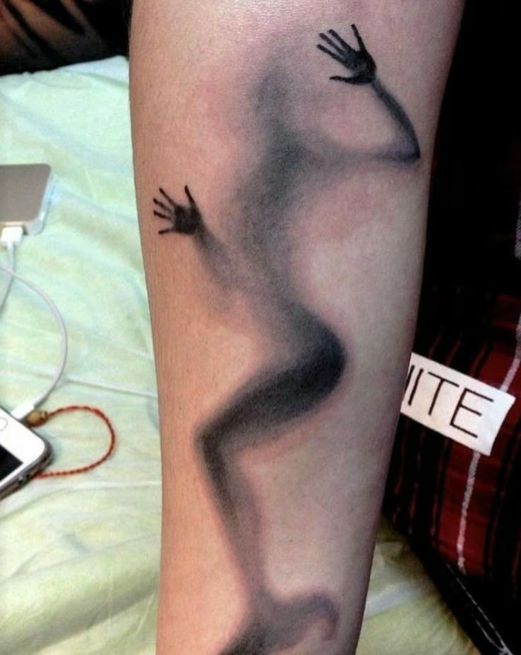 a person's leg with an artistically designed arm and foot tattoo on it