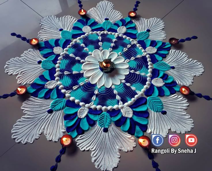 a blue and white decorative item with candles on the floor in front of an advertisement for rangoli by sneha