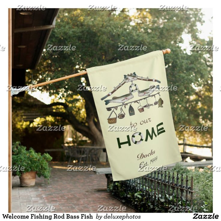 a welcome flag hanging from the side of a building with an image of a house on it