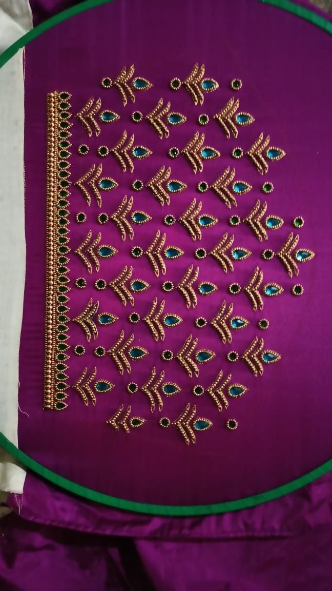 an embroidered purple cloth with gold and blue designs on the front, along with green trim