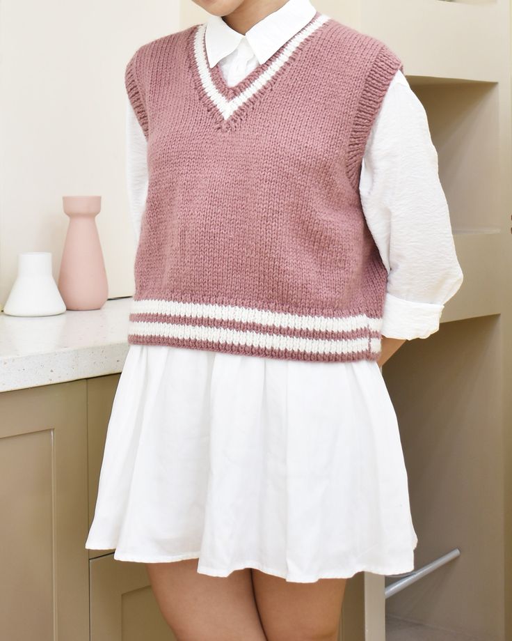 a woman in a short skirt and sweater standing next to a shelf with vases on it