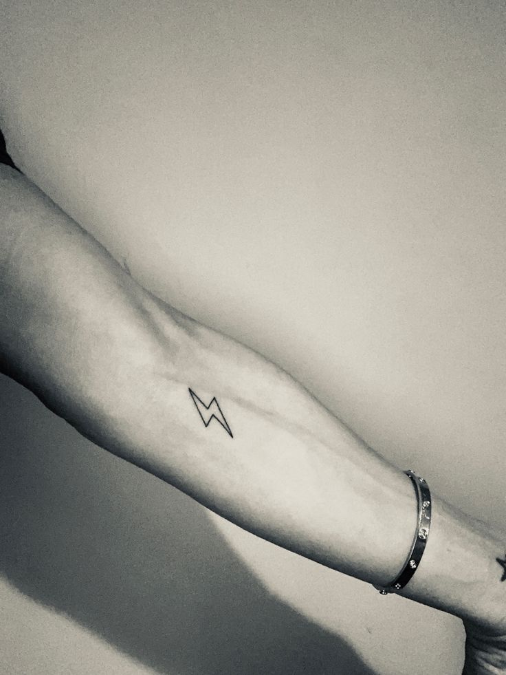 a person's arm with a small tattoo on it