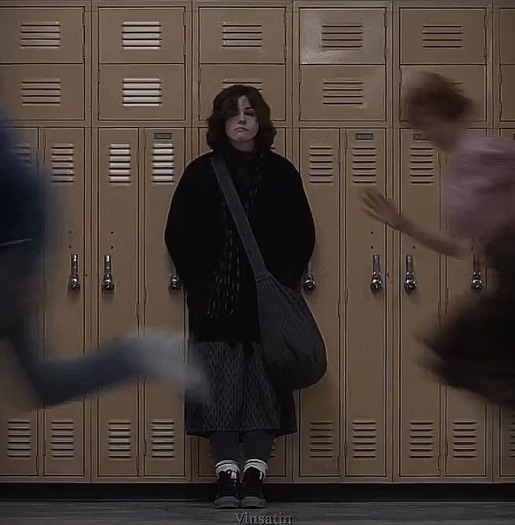 a woman is standing in front of lockers