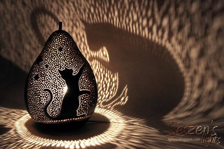 an artistically designed vase casts a shadow on the wall with its intricately patterned design