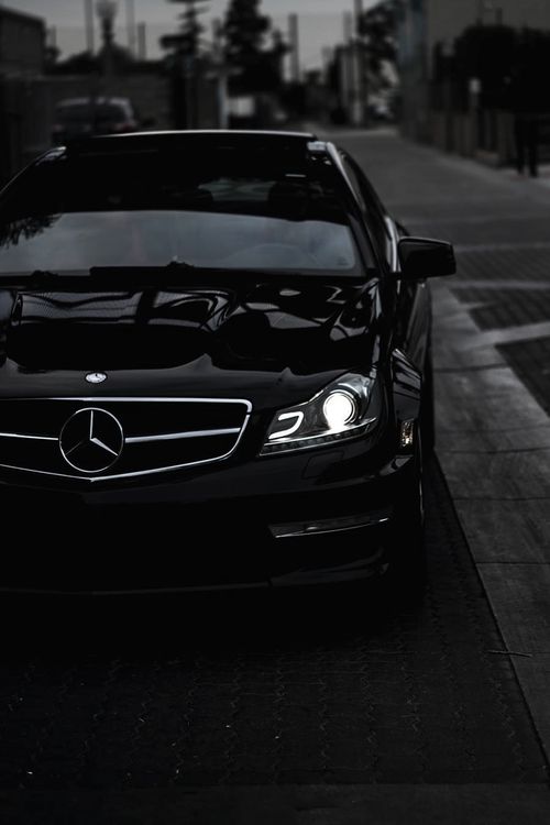 a black car parked on the side of a street