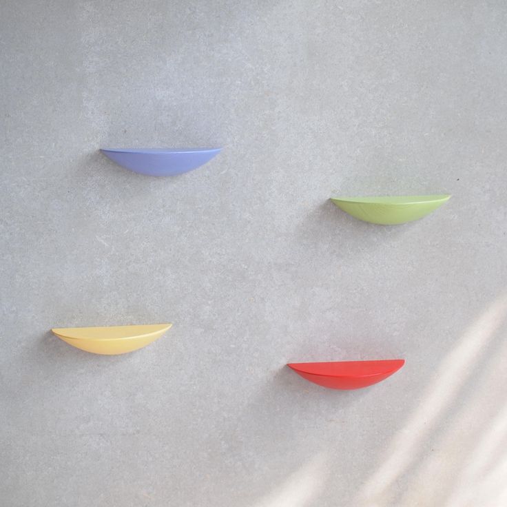 three different colored bowls hanging on the wall