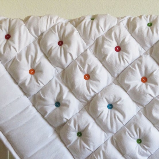 an up close view of a quilted bed with buttons on the back and sides