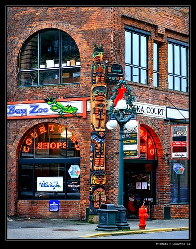 an old brick building with many signs on it's front and side windows, along with a red fire hydrant in the foreground