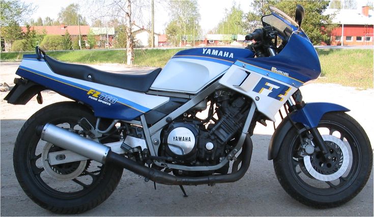 a blue and white yamaha motorcycle parked in a parking lot