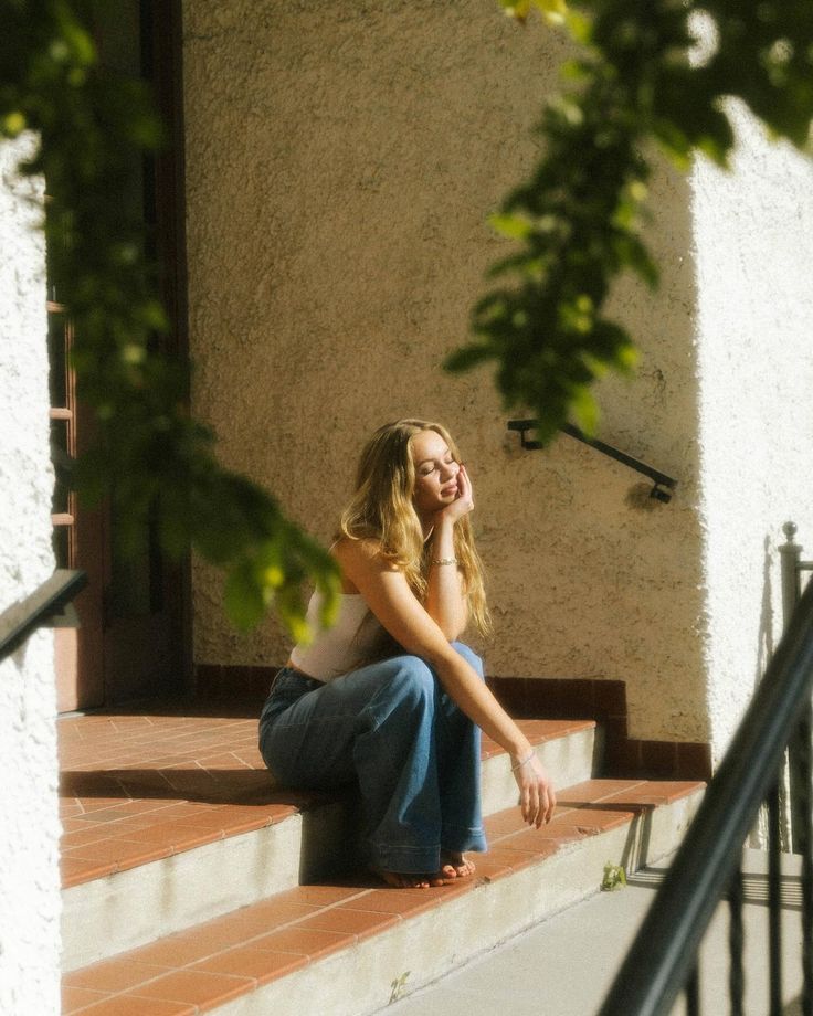 a woman sitting on the steps in front of a building