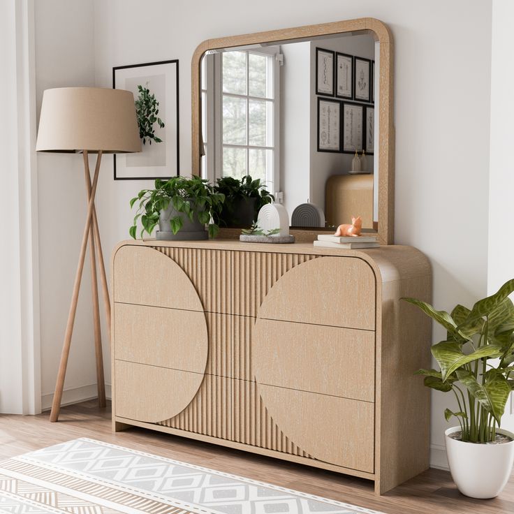 a living room with a large mirror and plant on the sideboard in front of it