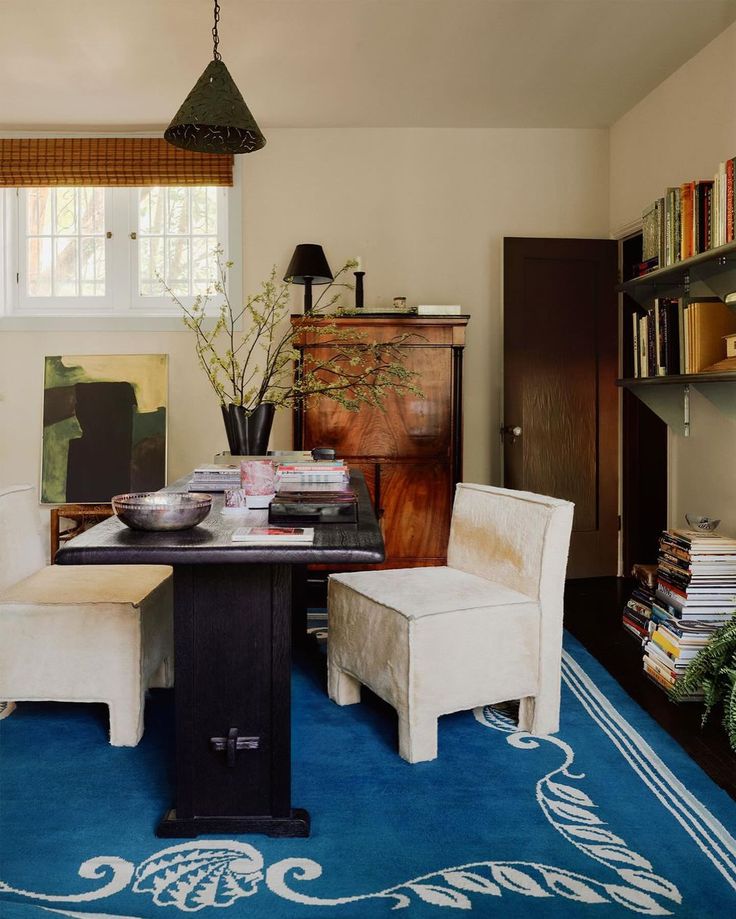 a room with a table, chairs and bookshelf in the corner is shown