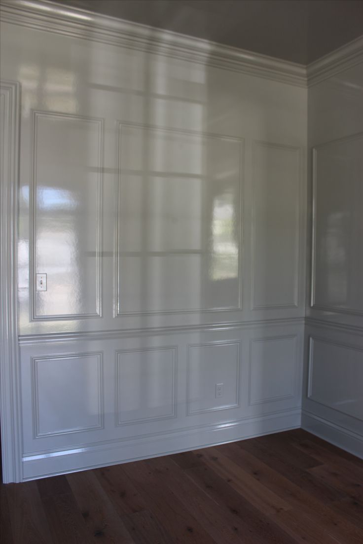 an empty room with white walls and wood floors