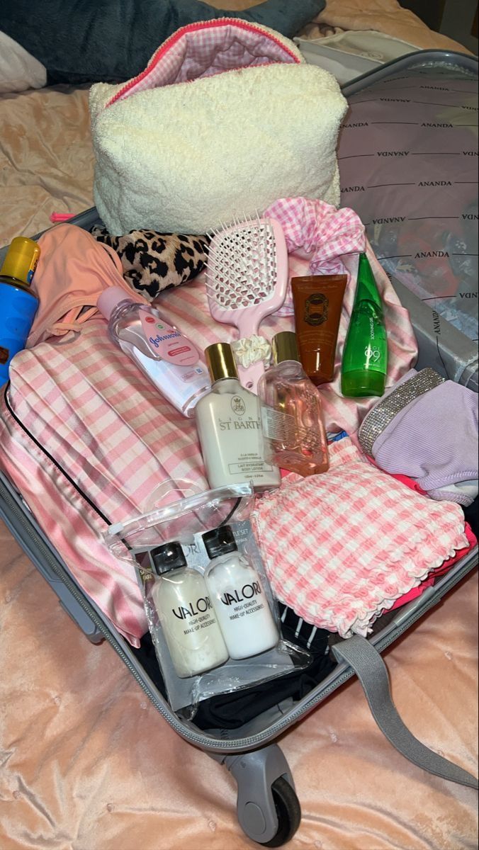 an open suitcase filled with personal items on a bed