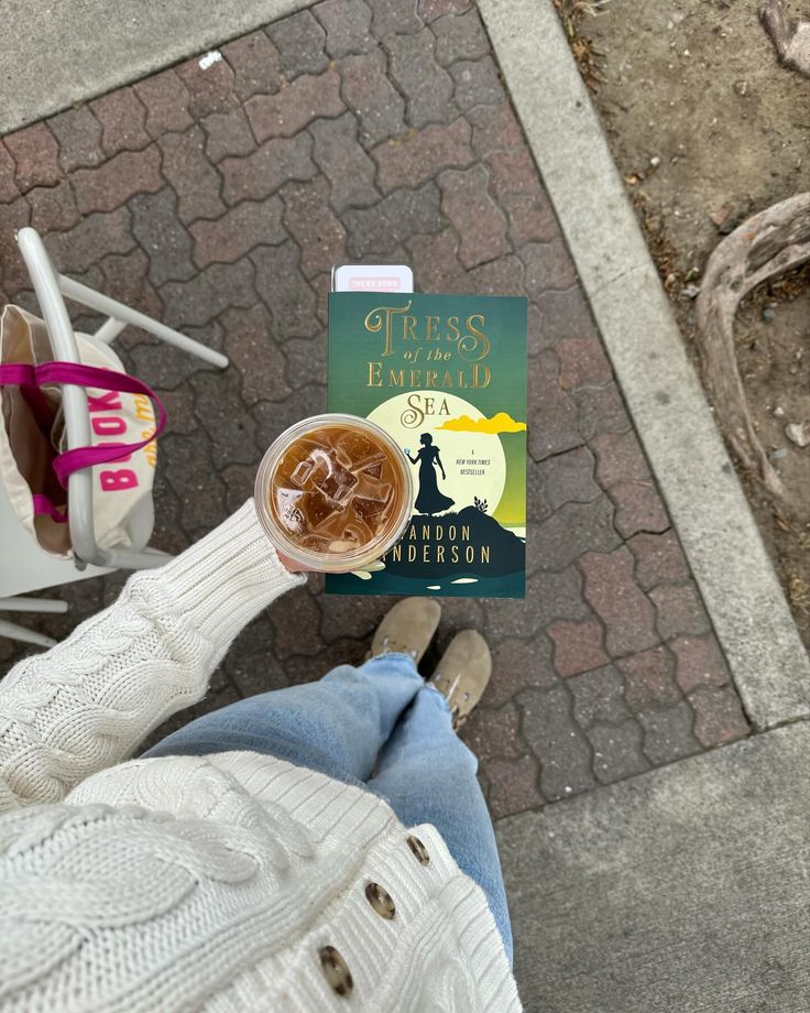 a person is holding up a book on the ground with their feet in the air