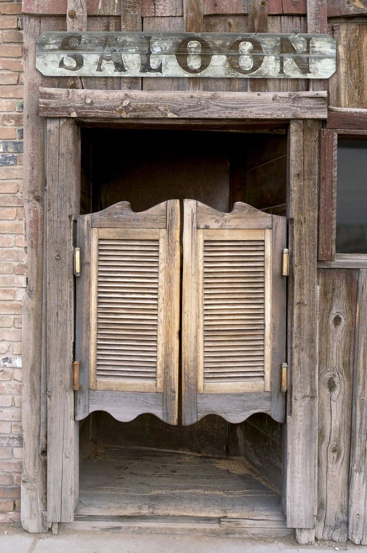 an old wooden door with shutters open in front of a brick building that says my black dropshop