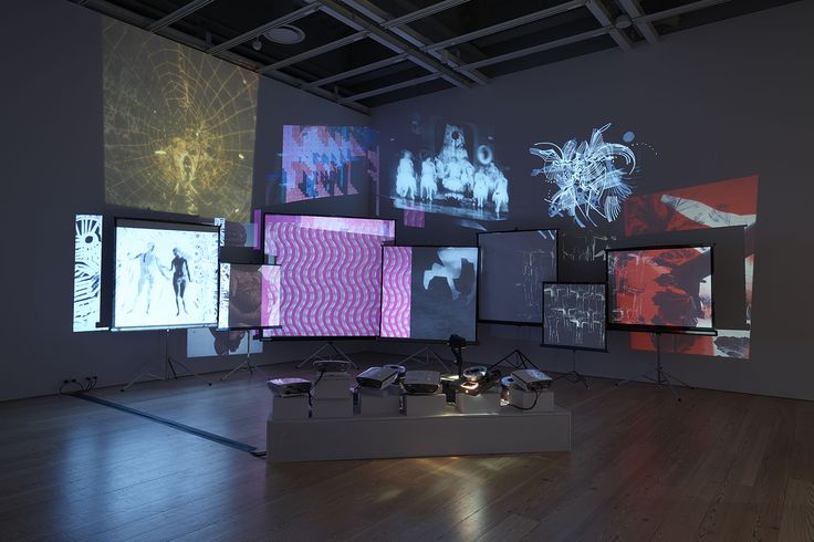 an art gallery with multiple screens on the wall