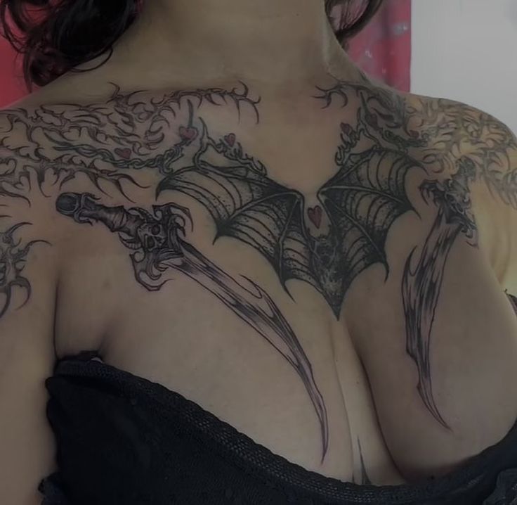 a woman with tattoos on her chest and shoulder