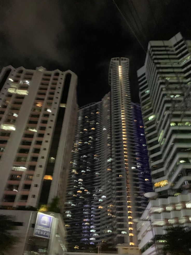 some very tall buildings in the city at night