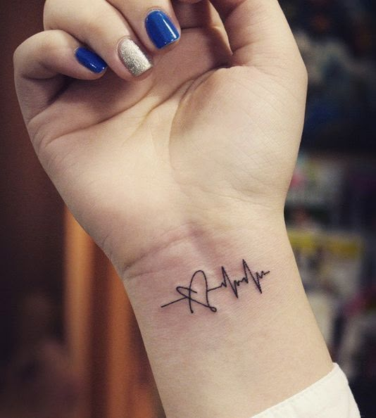 a woman's wrist with a heartbeat tattoo on it