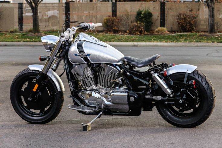 a silver motorcycle parked on top of a parking lot