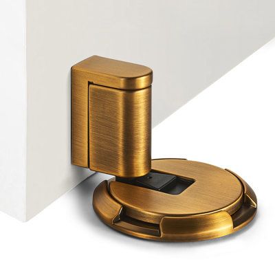 a close up of a door handle on a white wall with a metal object in the middle