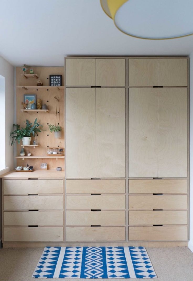 a room with wooden cabinets and rugs on the floor in front of it's shelves