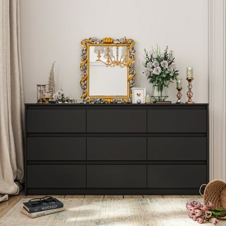 a dresser with flowers and a mirror on top