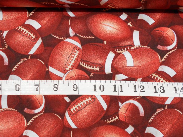 a measuring tape is in front of a large pile of red and white footballs