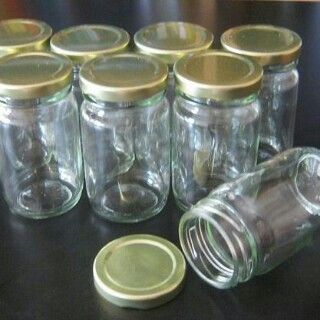 there are many empty glass jars with lids on the table next to each other,