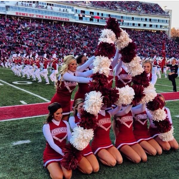 a group of cheerleaders standing in front of a christmas tree at a football game