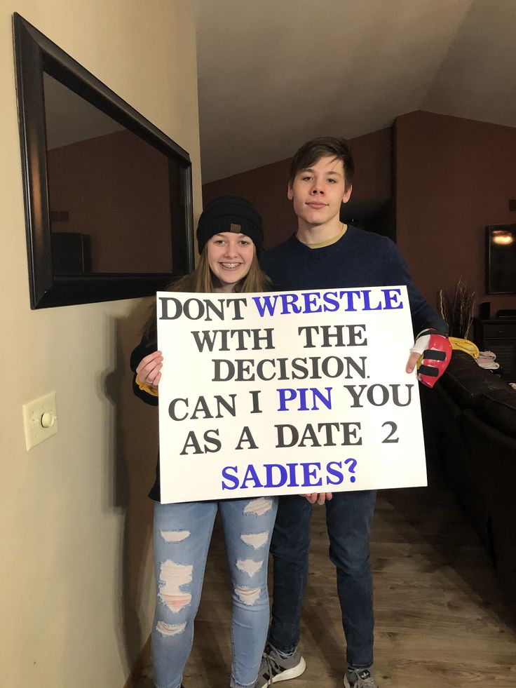 two people holding up a sign that says don't wrestle with the decision can i pin you as a date 2 sadies?