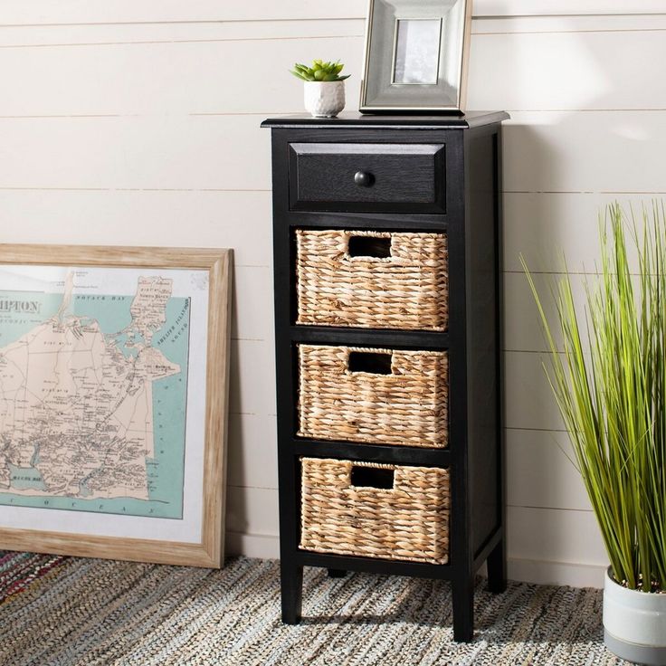 a black cabinet with three wicker baskets on top and a map in the background