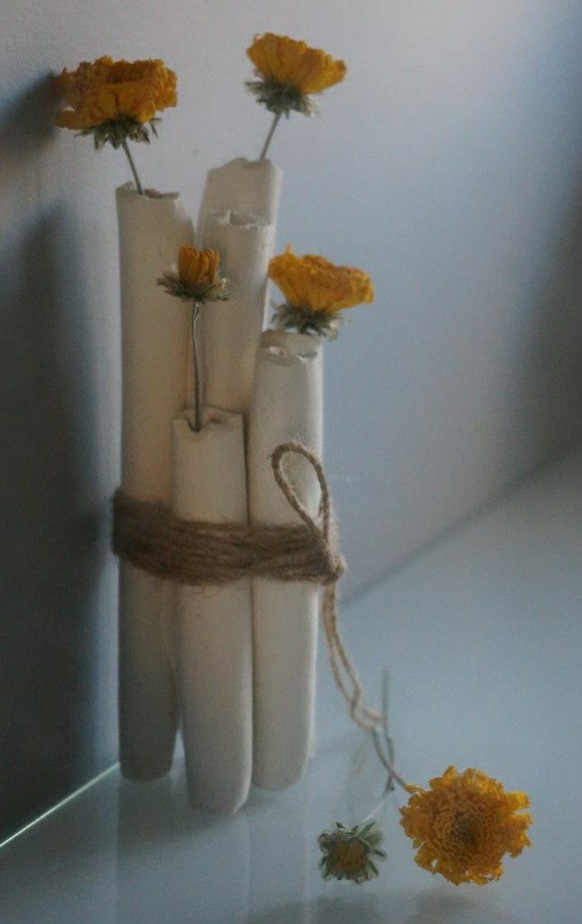 three white candles tied with twine and yellow flowers