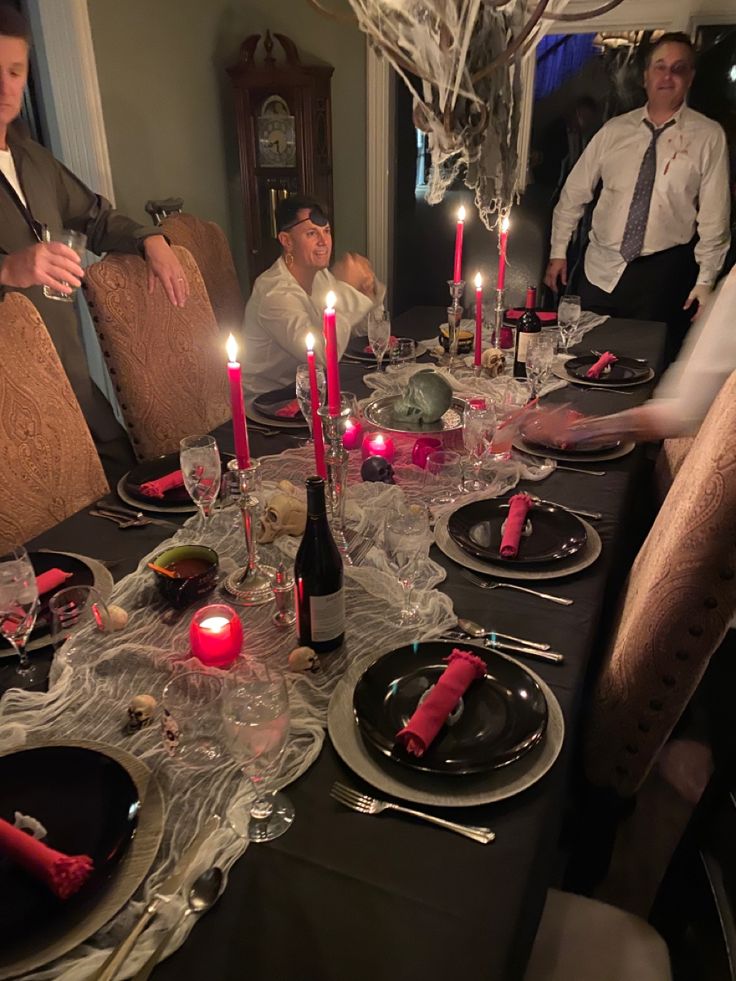 a group of people sitting around a table with plates and candles in front of them