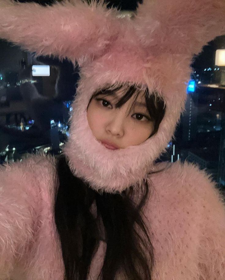 a woman with long black hair wearing a pink bunny costume