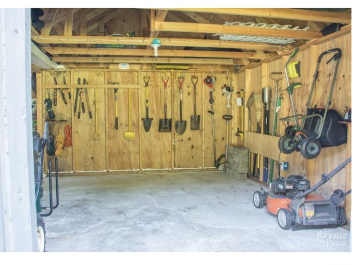 the inside of a garage with tools hanging on the wall and an electric lawn mower